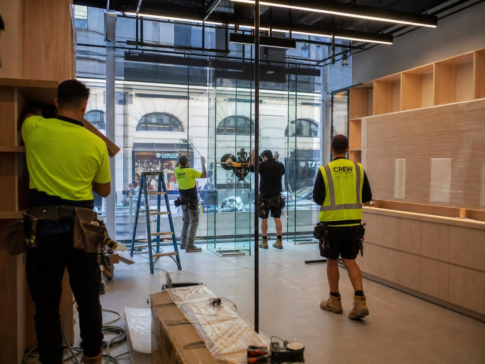 Australian shopfitting crew installing glass shopfront and joinery in a Sydney CBD retail fitout
